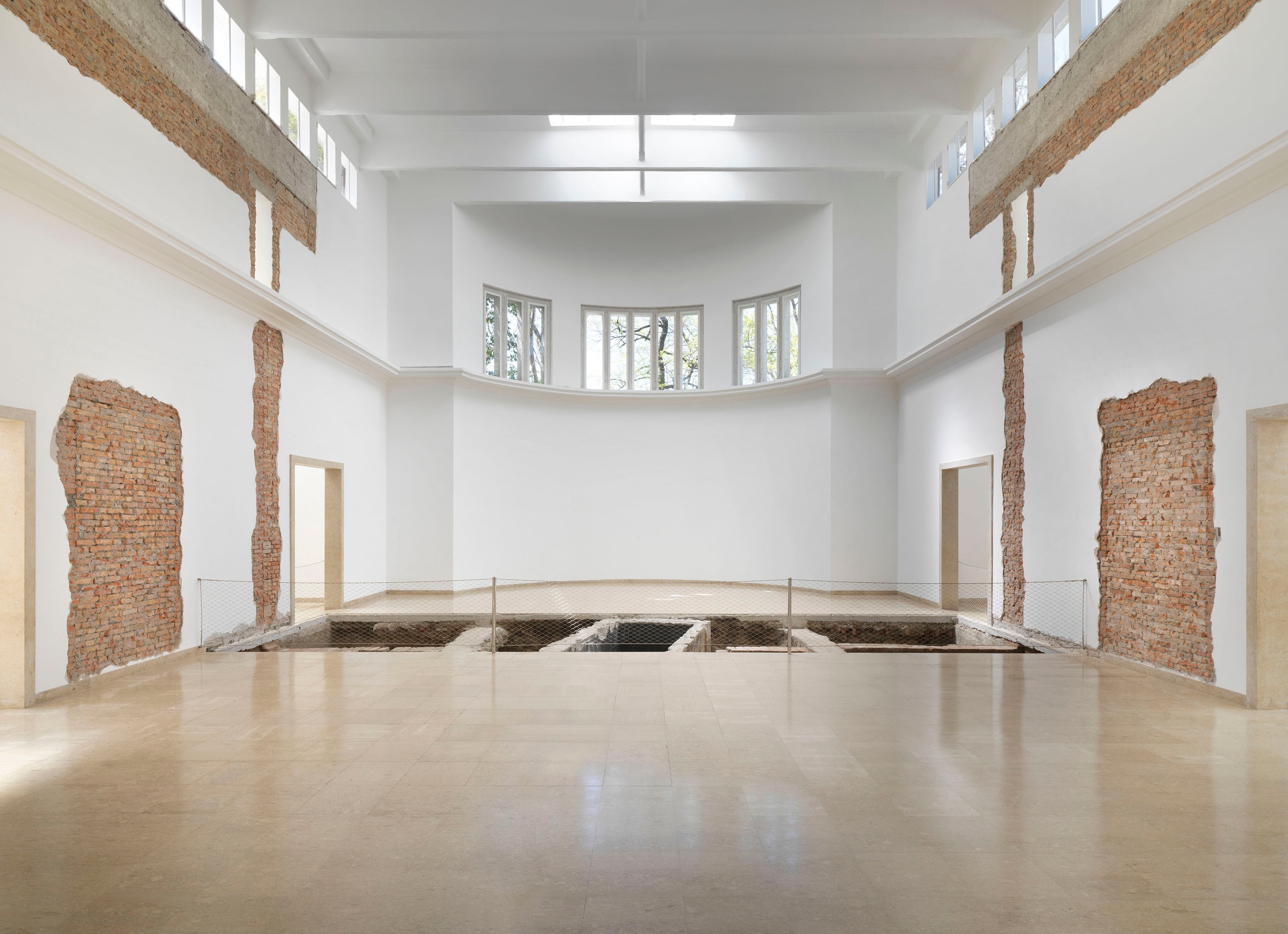 Maria Eichhorn, Relocating a Structure. German Pavilion 2022, 59th International Art Exhibition – La Biennale di Venezia, 2022, detail: Joins between sections of the building from 1909 and 1938; wall lettering; doorway to the left rear side room from 1909, walled up in 1928; foundations of the rear wall from 1909; rear wall of the building from 1909, interior wall from 1938, demolished in 1964; doorway to the right side room from 1909, walled up in 1912, exhibition view, © Maria Eichhorn / VG Bild- Kunst, Bonn 2022, photo: Jens Ziehe